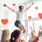 People celebrating in an office with floating hearts